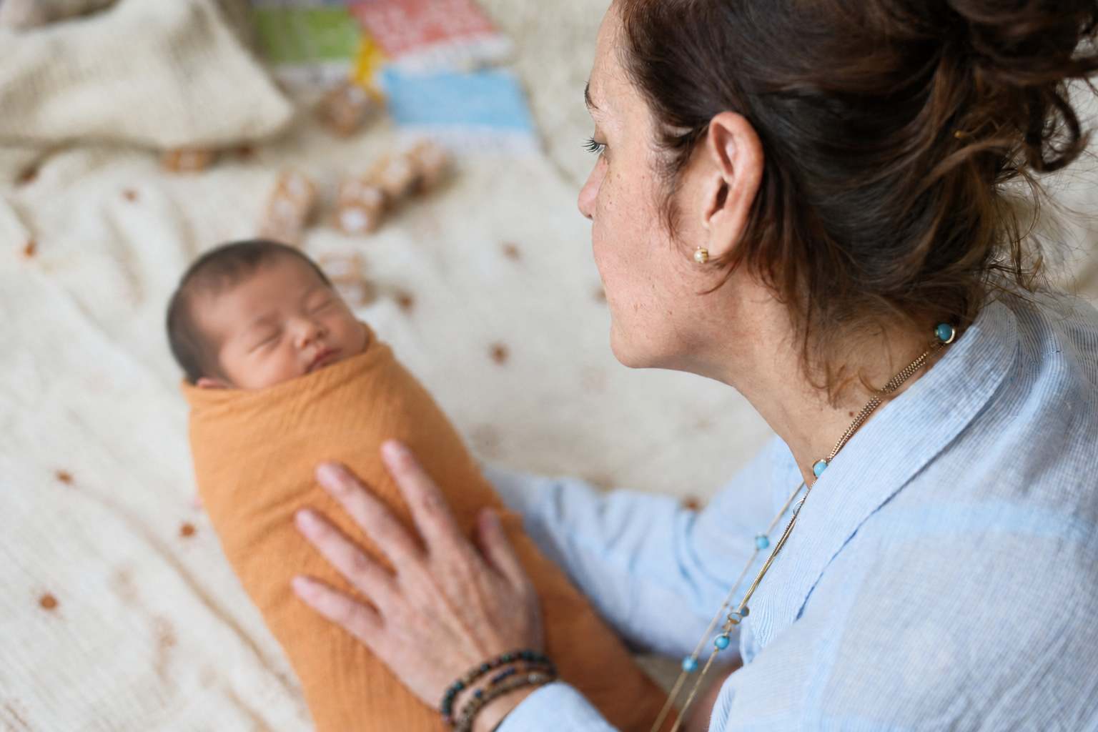 Priscilla holding a swaddled newborn baby